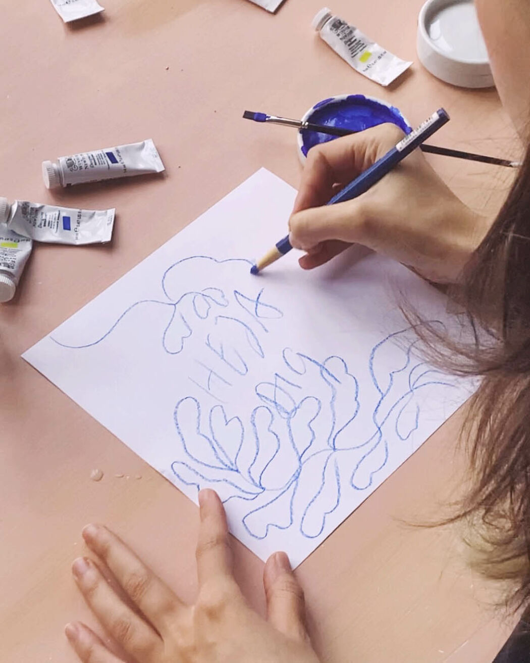 The artist Linnéa Andersson in her studio working with sketches for a tech brand